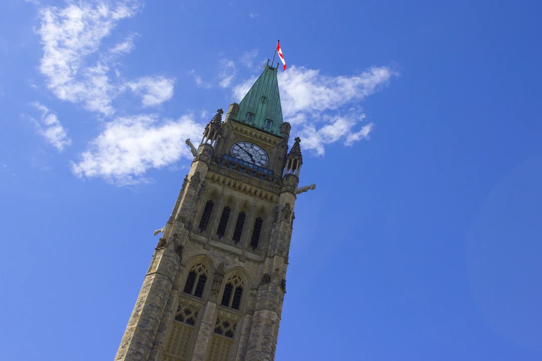 The Peace Tower of Canada's Parliament in Ottawa against a blue sky with a few clouds